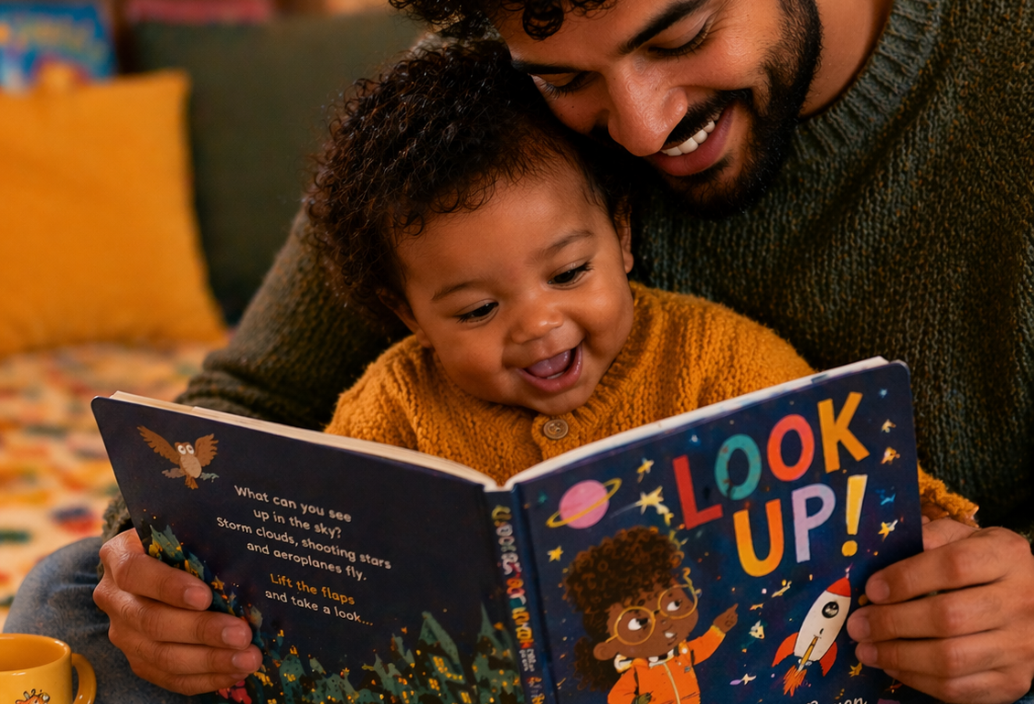 Close-up of a smiling father sitting on the floor with his baby, reading a colourful picture book together in a warm, cosy room, with soft lighting and children’s books in the background.